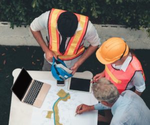 3 workers looking at roofing plans