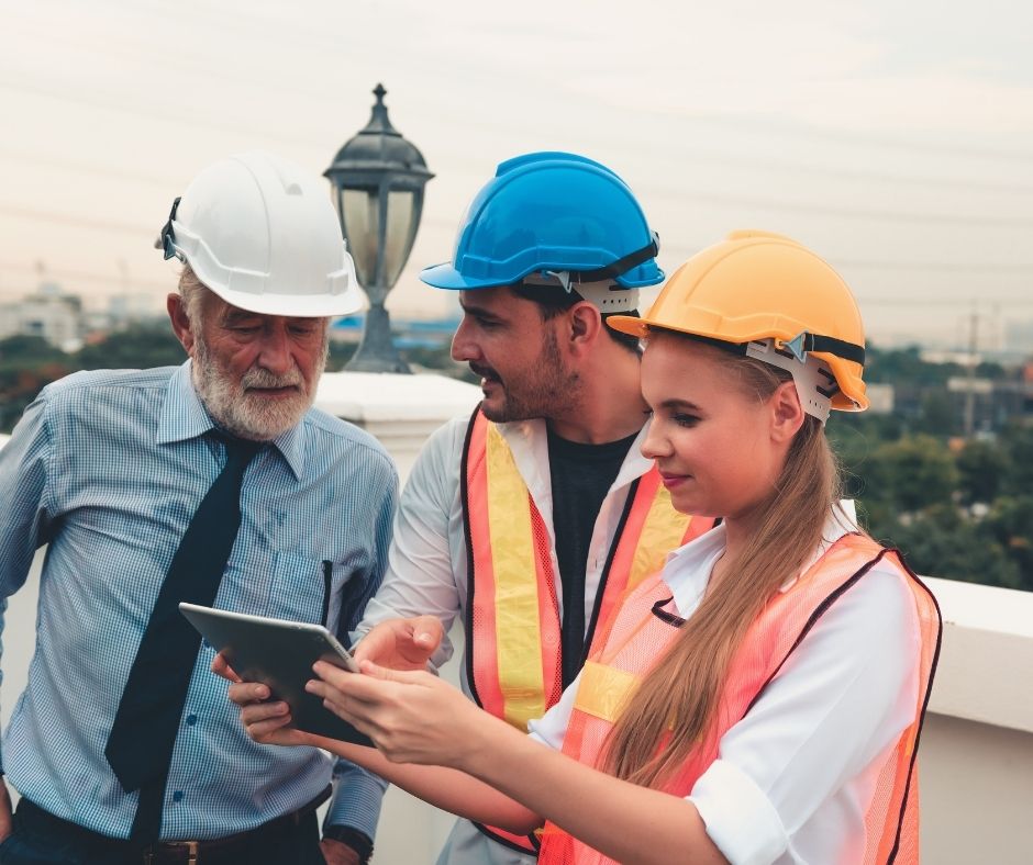 3 workers looking at roofing plans